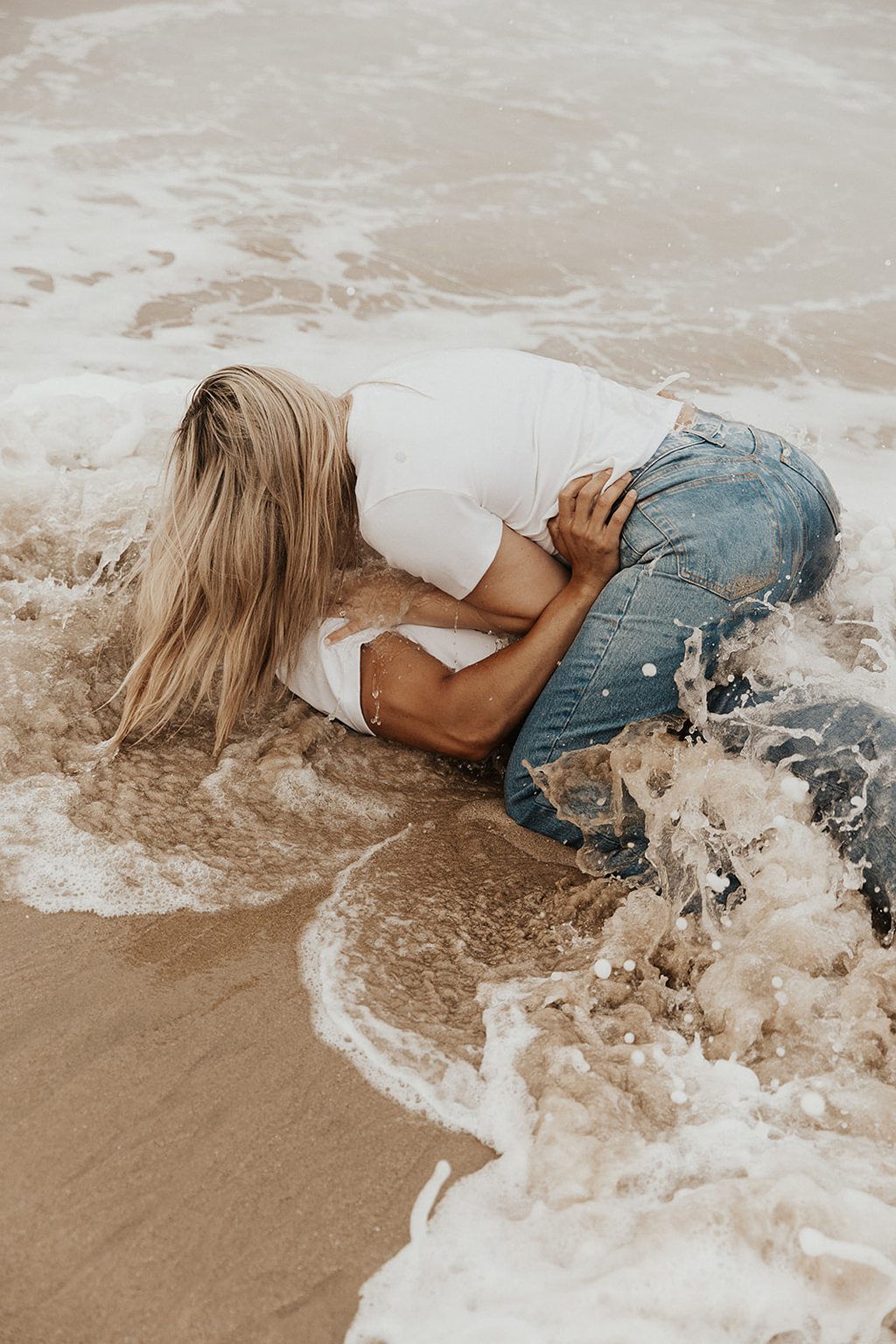 Couple in water during beach engagement photoshoot in Laguna Beach photographed by NICOLE KIRSHNER